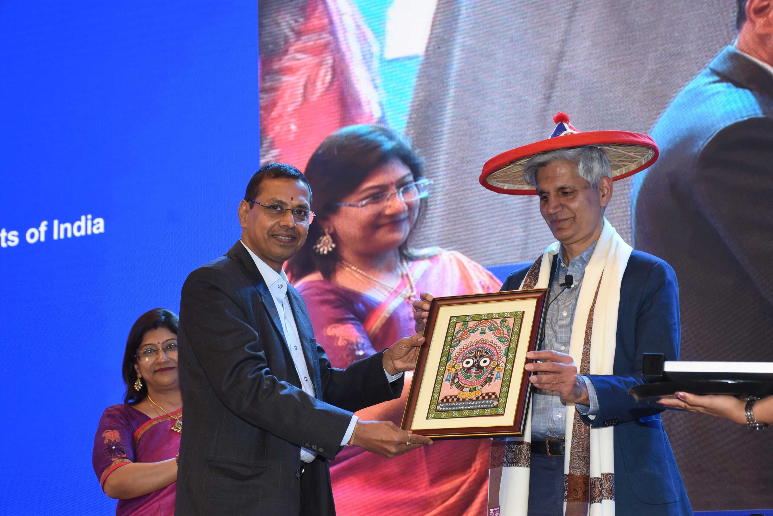 Hitendra Wadhwa holding a picture on stage