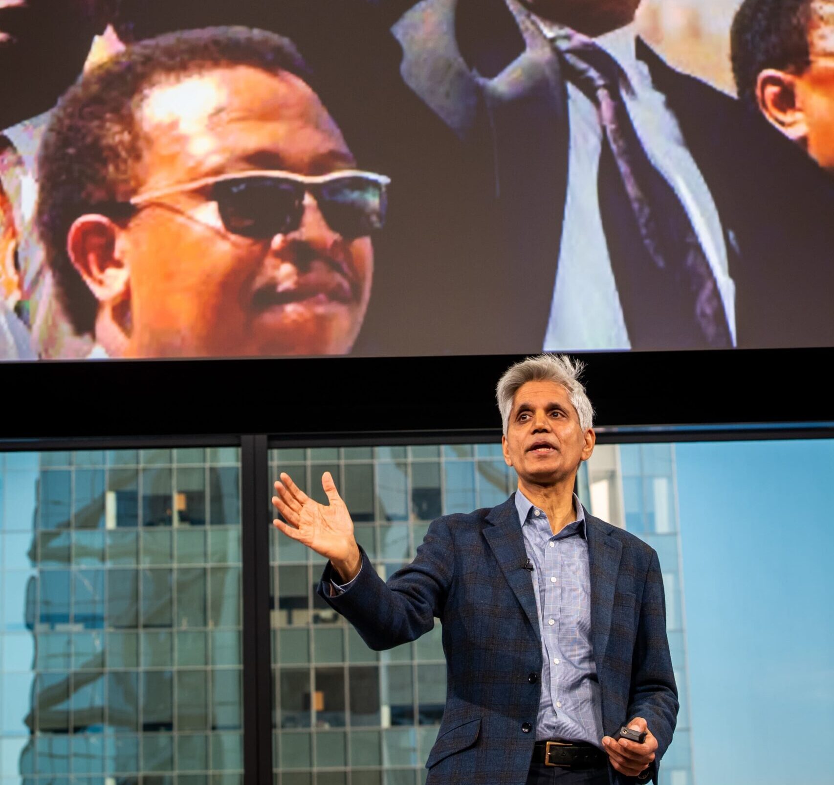 Hitendra Wadhwa speaking at the Comcast Event with Nelson Mandela's picture in background