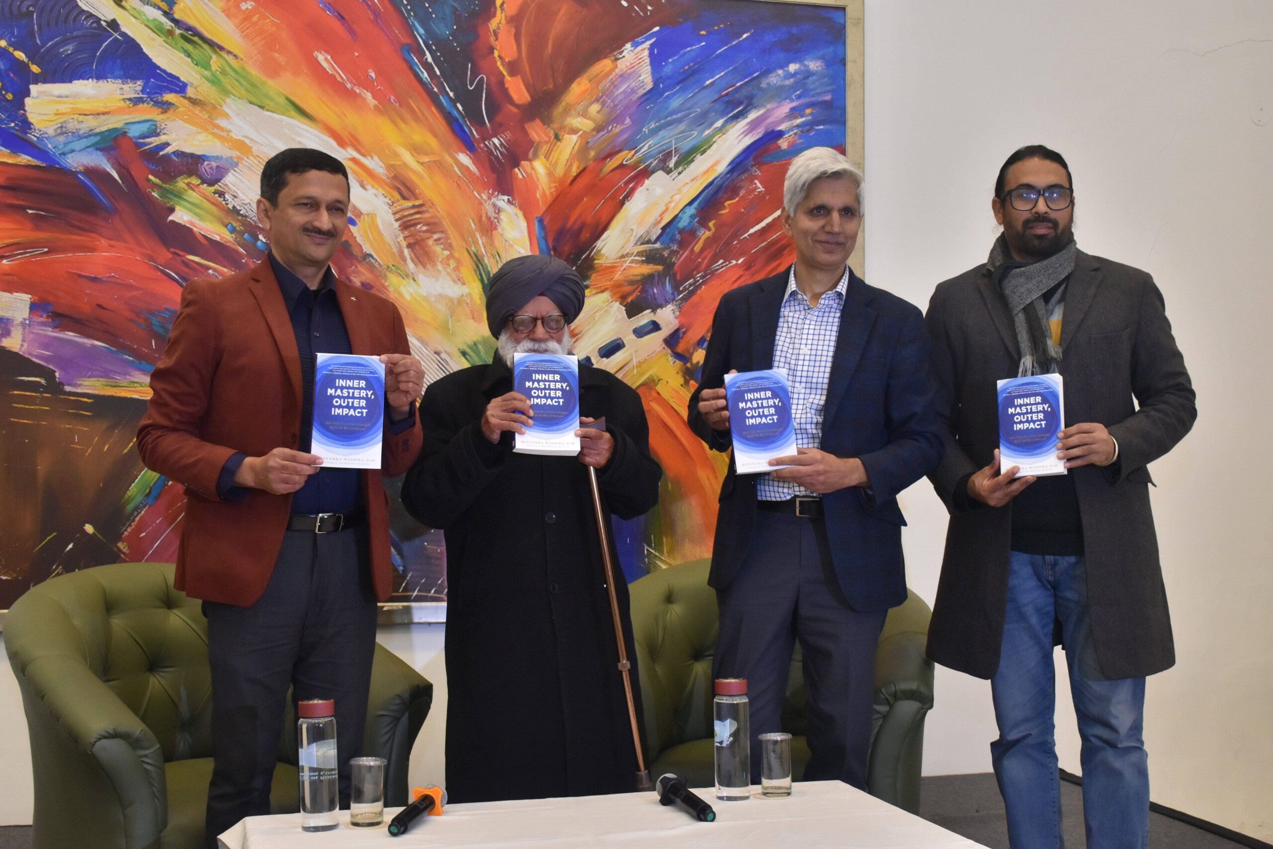 Hitendra Wadhwa with three men holding the book 'Inner Mastery, Outer Impact'