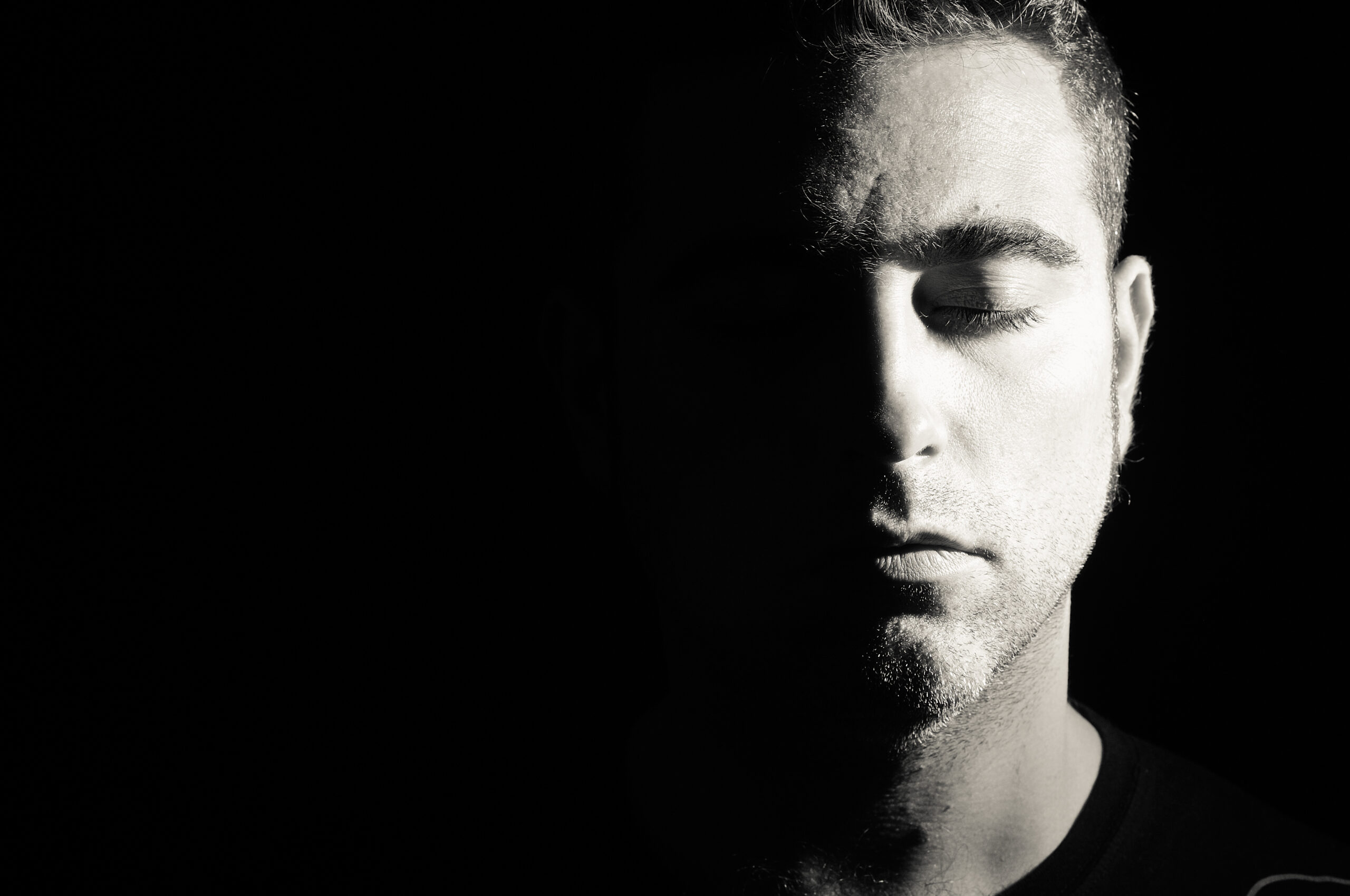 Close-up Of Man With Eyes Closed Against Black Background indicating the power of pause.