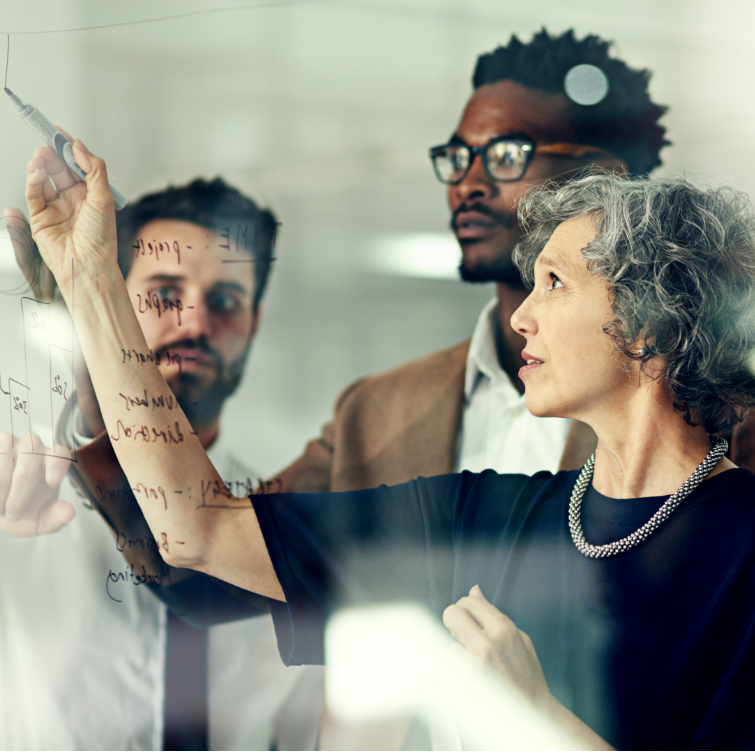 a group of executives brainstorming with notes on a glass wall indicating Leading from Your Inner Core.