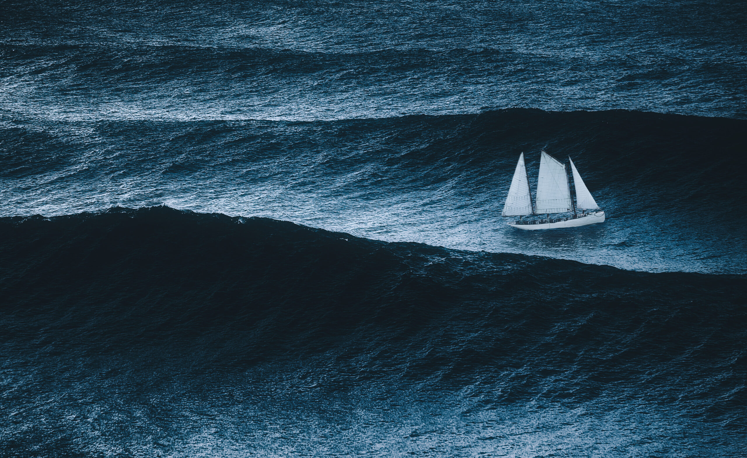A sailboat on the sea with storm and big waves, navigating uncertainty